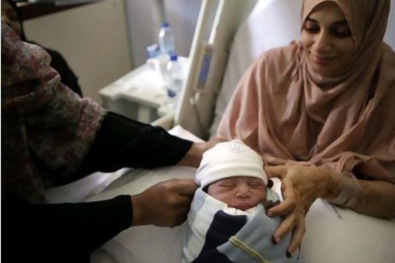 Salema Al Ghunami holds her newborn son Falah Al Ameri, born at 12.01am, 11/11/11, at the Corniche Hospital.