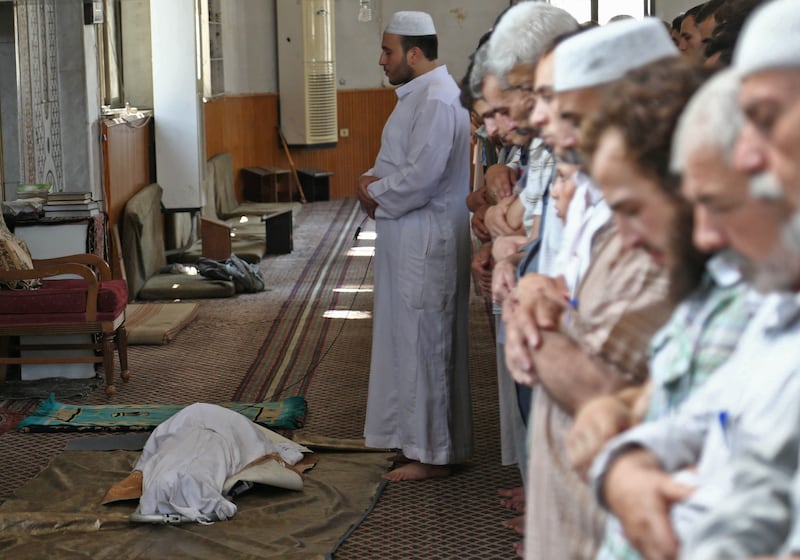 Syrians pray in a mosque over the body of a child who was reportedly killed during regime shellings in the rebel-controlled town of Hamouria, in the eastern Ghouta region on the outskirts of the capital Damascus, on August 10, 2017. / AFP PHOTO / ABDULMONAM EASSA