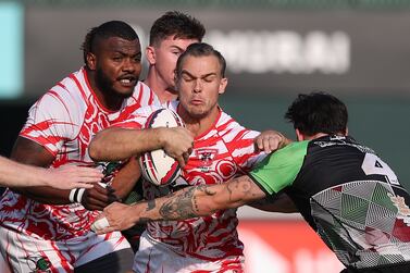 Dubai Tigers (red and white) beat Abu Dhabi Harlequins in the Gulf mens final at the Dubai Rugby 7's. Chris Whiteoak / The National