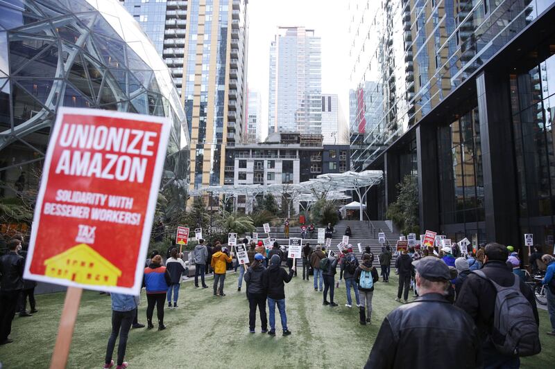 In this file photo taken on March 26, 2021 people hold pro-union signs during a rally at the Amazon Spheres and headquarters in Seattle in solidarity with Amazon workers hoping to unionise in Bessemer, Alabama. AFP