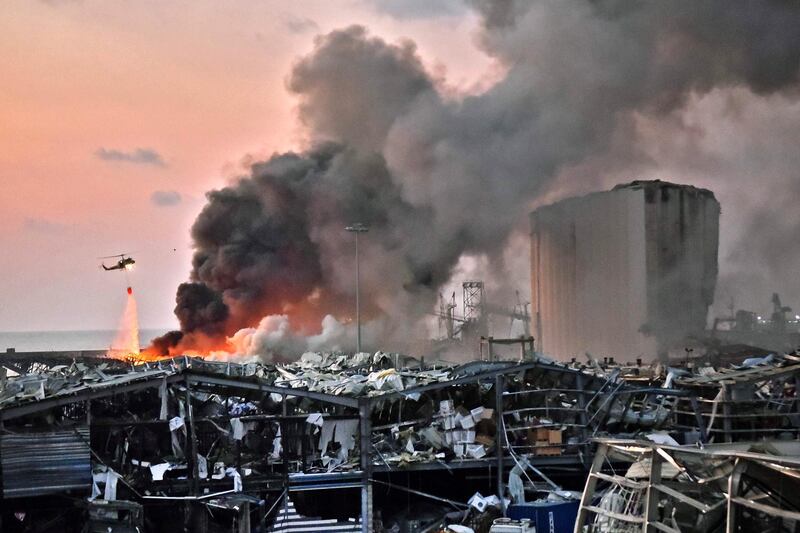 EDITORS NOTE: Graphic content / A helicopter puts out a fire at the scene of an explosion at the port of Lebanon's capital Beirut on August 4, 2020.  / AFP / STR
