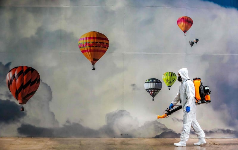 An employee wearing protective gear disinfects a shopping mall as a preventive measure against the coronavirus in Caxias do Sul, Brazil.  AFP