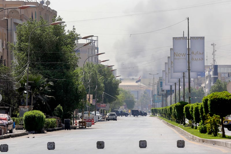 Smoke billows in the background in the capital Baghdad during an army-imposed nationwide curfew a day after 23 supporters of powerful Shiite leader Moqtada Al Sadr were shot dead during fighting in Baghdad's Green Zone. AFP