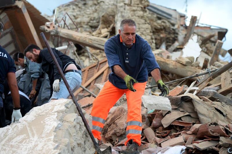 Rescuers clear debris while searching for victims in damaged buildings after a strong heartquake hit Amatrice. The hardest-hit towns were Amatrice and Accumoli near Rieti, some 100 kilometres northeast of Rome, where the air was thick with dust and smelled strongly of gas. Filippo Monteforte / AFP