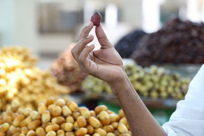 A customer examines a fresh date at the Souq Al Jubail Seventh Annual Dates Festival.
