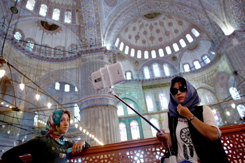 A South Korean tourist (right) takes a selfie as she visits the Ottoman-era Sultanahmet mosque, also known as the Blue Mosque, in Istanbul. Murad Sezer / Reuters