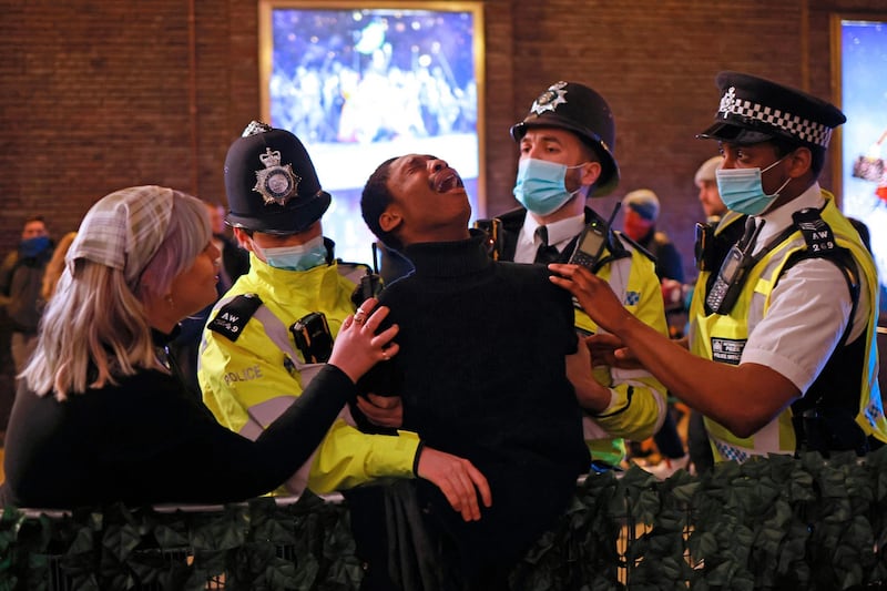 Police officers wearing protective face coverings make an arrest in the Soho area of London. AFP