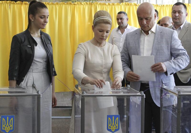 Former prime minister and presidential candidate Yulia Tymoshenko, centre, accompanied by her daughter Yevgenia, left, and husband Oleksander, right, casts her vote during a presidential election at a polling station in Dnipropetrovsk on May 25, 2014. Valentyn Ogirenko/Reuters
