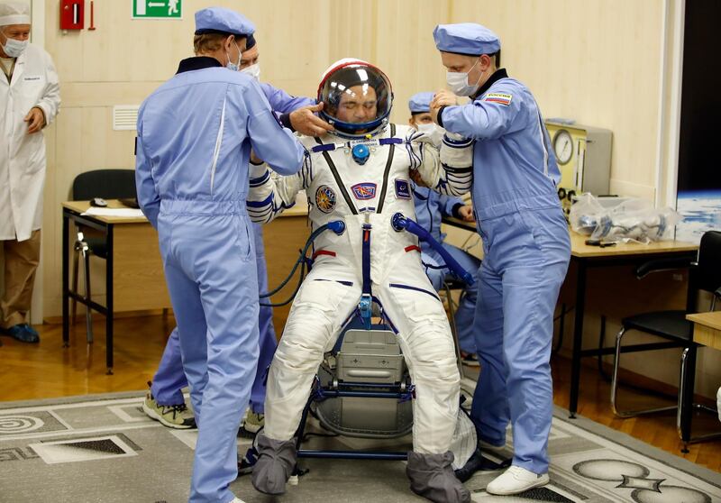 Russian Space Agency experts help Russian cosmonaut Oleg Skripochka stand up after inspecting his space suit. Dmitri Lovetsky / AP