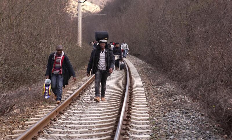 In this February 28, 2015 photo, West African migrants walk on train tracks on their way towards the border with Macedonia near the town of Evzonoi, Greece. Dalton Bennett/AP Photo  