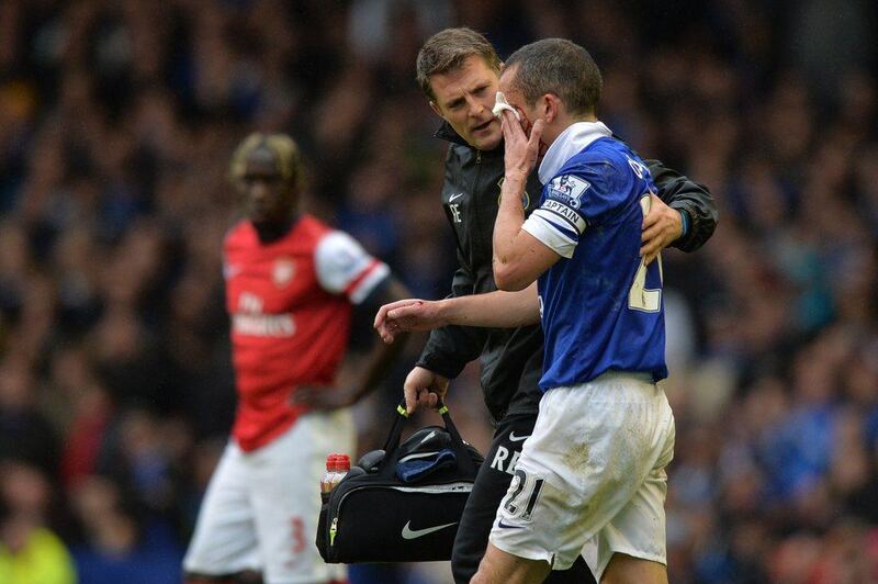 Everton midfielder Leon Osman gets attention as he bleeds after picking up an injury in a tackle with Arsenal defender Bacary Sagna during Everton's win over Arsenal on Sunday. Paul Ellis / AFP / April 6, 2014