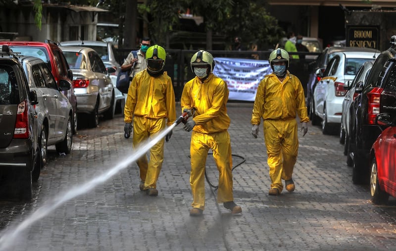 Members of a municipal fire brigade spray disinfectant in Mumbai, India.  EPA