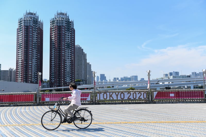 A bicyclist travels past a banner for the Tokyo 2020 Olympic Games on Yume-no-Ohashi Bridge in Tokyo, Japan on Thursday.