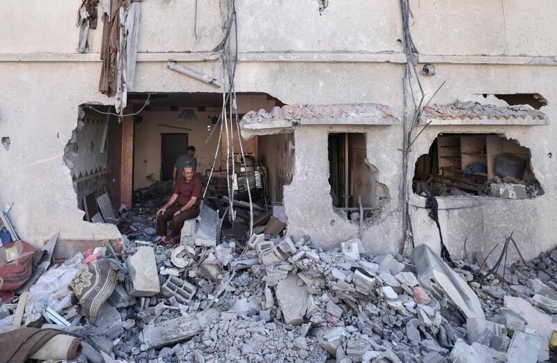 A Palestinian man sits inside his damaged home in Gaza City. AFP