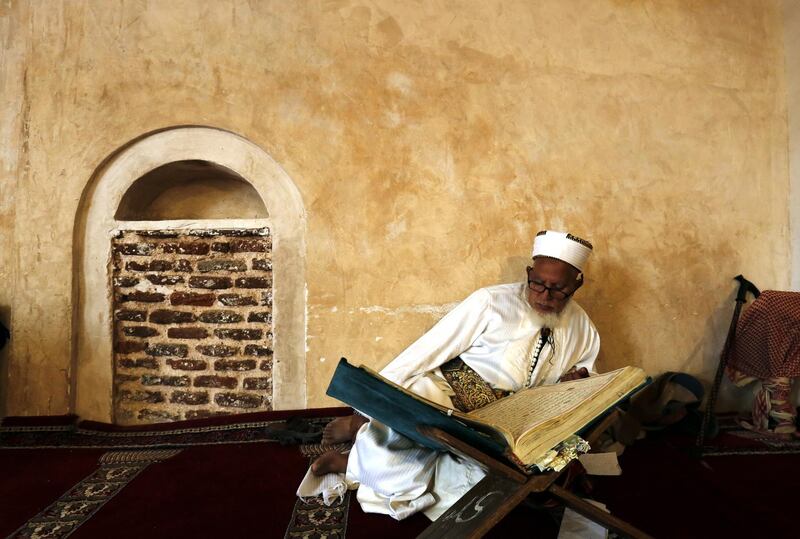 A Yemeni man reads the Quran at a mosque in Sanaa. EPA