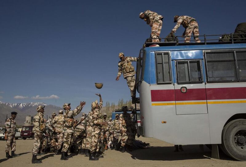 Security force soldiers on election duty unload equipment off a bus as they leave a central collection point to head for a polling station.