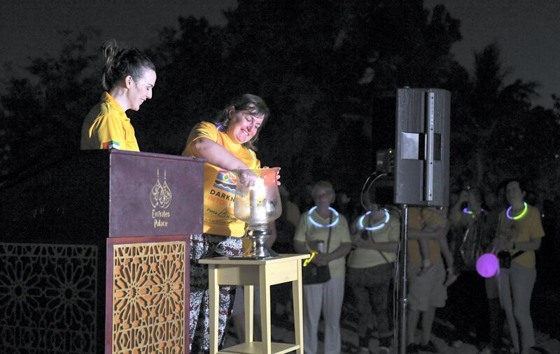 Abu Dhabi, United Arab Emirates - Caroline lights a candle before the walk begins at Emirates Palace. Khushnum Bhandari for The National
