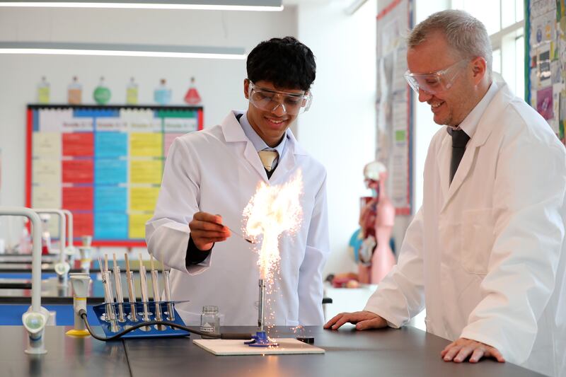 Kirk, aged 18, with Michael Darby, head of science, conducts an experiment without face masks at Brighton College in Dubai.
