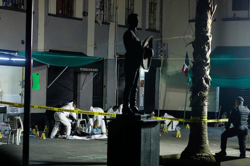 Crime scene workers cover the bodies of victims of a shooting in Garibaldi Plaza, in Mexico City, Friday Sept. 14, 2018. Mexican authorities say four people have been killed and nine wounded in a shooting at the capitalâ€™s emblematic Garibaldi Plaza, a popular spot for tourists. (AP Photo/Stringer)