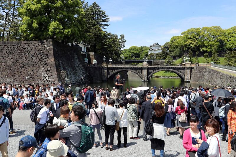 People gather in the compound near Imperial Palace in Tokyo. Japan has new Emperor Naruhito to perform his first ritual after succeeding the Chrysanthemum Throne from his father Akihito who abdicated the night before.  AP