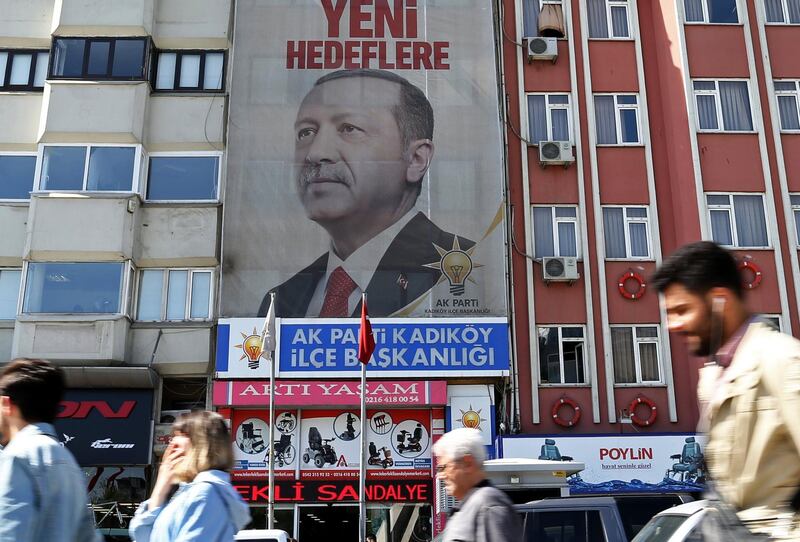 epa06679392 People walking under a huge picture of Turkish President Recep Tayyip Erdogan in Istanbul, Turkey, 19 April 2018. The presidental and parliamentary elections were scheduled to be held in November 2019, but government has decided the change the date following the recommendation of the Nationalist Movement Party (MHP) leader Devlet Bahceli.  EPA/ERDEM SAHIN
