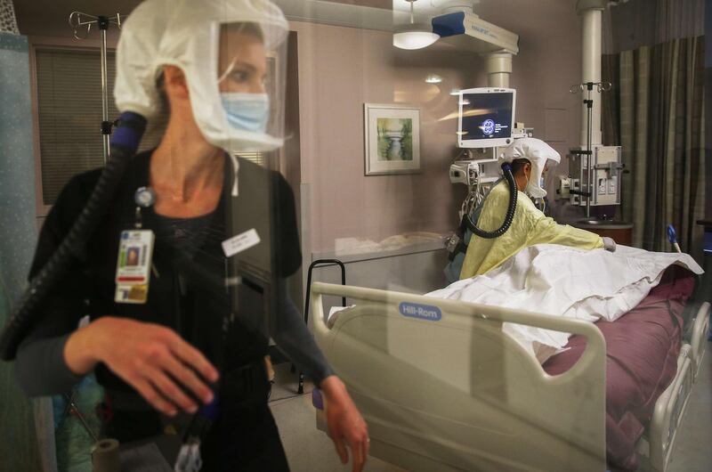 LA MESA, CALIFORNIA - DECEMBER 14: (EDITORIAL USE ONLY) Registered nurses Lindsey Ryan (L) and Carrie Tang provide post-mortem care to a deceased COVID-19 patient in the Intensive Care Unit at Sharp Grossmont Hospital on December 14, 2020 in La Mesa, California. According to state figures, Southern California, which includes San Diego County, currently has only 1.7 percent of its ICU (Intensive Care Unit) bed capacity remaining amid a spike in COVID-19 cases and hospitalizations. Sharp HealthCare is the largest health system in San Diego County.   Mario Tama/Getty Images/AFP
== FOR NEWSPAPERS, INTERNET, TELCOS & TELEVISION USE ONLY ==
