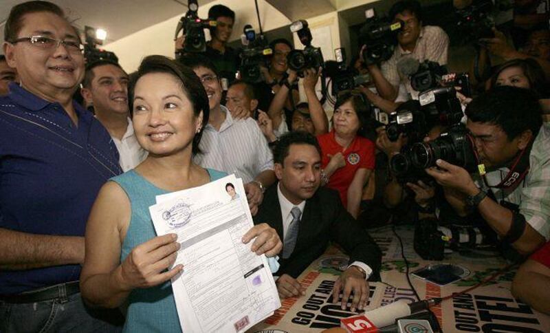 Gloria Macapagal Arroyo, the president of the Philippines, with husband Mike, left, at the election commission office near Manila yesterday.