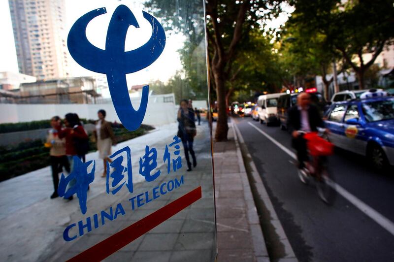 FILE PHOTO: People walk past a China Telecom public phone booth at a street in Shanghai October 28, 2013.  REUTERS/Carlos Barria/File Photo                 GLOBAL BUSINESS WEEK AHEAD