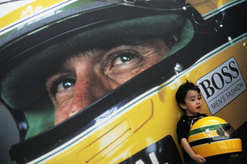 A child poses for a promotional picture holding a replica of a helmet used by thrice world champion late Brazilian Formula One driver Ayrton Senna, during a promotional event to collect funds for the Ayrton Senna Institute on April 13, 2006 in Sao Paulo, Brazil. Mauricio Lima / AFP