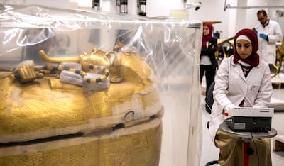epa07755896 An Egyptian archeologist works next to the gilded coffin of King Tutankhamun that is undergoing a restoration process at the Grand Egyptian Museum in Giza, Egypt, 04 August 2019. The gilded coffin of king Tutankhamun was transported in mid-July from his tomb at the Valley of the Kings in Luxor to the Grand Egyptian Museum for an eight-month restoration process, the first since the tomb was discovered in 1922, before displaying among his treasured collection at the museum.  EPA/MOHAMED HOSSAM