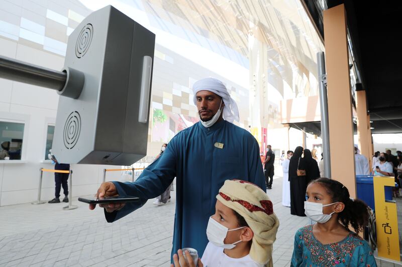 Jaber, with his children Theyab, 6, and Shasna, 7, scans their tickets. 'We are looking forward to seeing the UAE pavilion, its our home country,' he said. Chris Whiteoak / The National