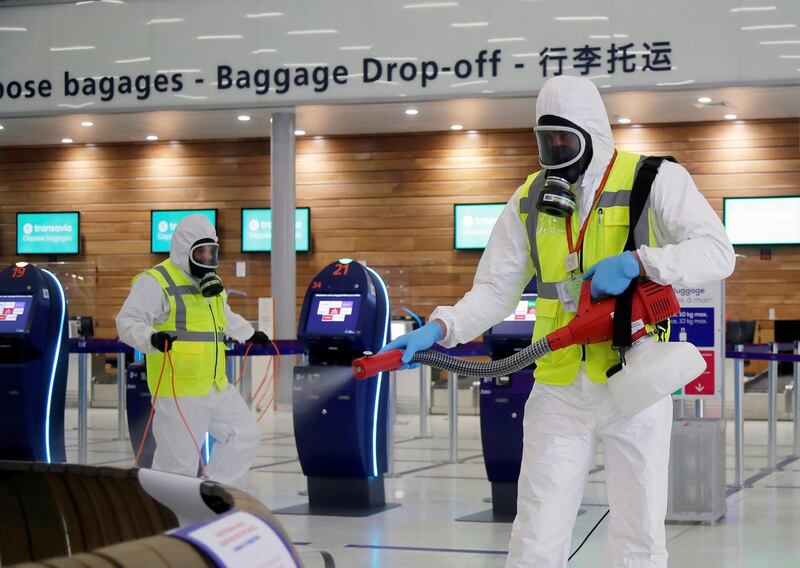 A worker in protective gear sprays disinfectant at Paris-Orly Airport on its re-opening. Reuters