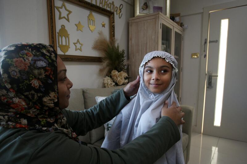 Niina Kaydee adjusts daughter Amelia's prayer clothing ahead of afternoon asr prayer at their home in Sydney, Australia. Getty Images