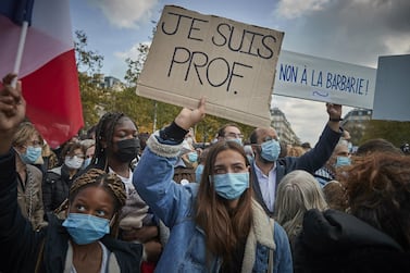 PARIS, FRANCE - OCTOBER 18: Protestors hold 'Je Suis Prof' placards during an anti-terrorism vigil at Place de La Republique for the death of Samuel Paty who was murdered in a terrorist attack in the suburbs of Paris on October 18, 2020 in Paris, France. Je Suis Prof has emerged reminiscent to Je Suis Charlie which emerged in the aftermath of the 2015 terrorist attack on the newspaper Charlie Hebdo. France launched an anti-terrorism investigation after the October 16 incident where police shot the 18 year-old assailant who decapitated the history-geography teacher for having shown a caricature of prophet Mohamed as an example of freedom of speech at the College Bois d'Aulne middle-school. (Photo by Kiran Ridley/Getty Images)