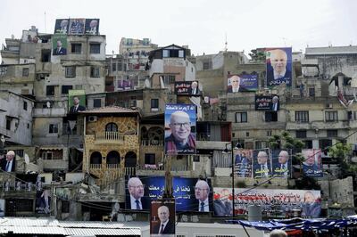 Posters of candidates for the upcoming Lebanese parliamentary elections hang on the walls of buildings in northern Lebanese city Tripoli's adjacent Bab al-Tabbaneh and Jabal Mohsen neighbourhoods on May 3, 2018. - Lebanon will be holding its first parliamentary elections since 2009 on May 6. (Photo by JOSEPH EID / AFP)