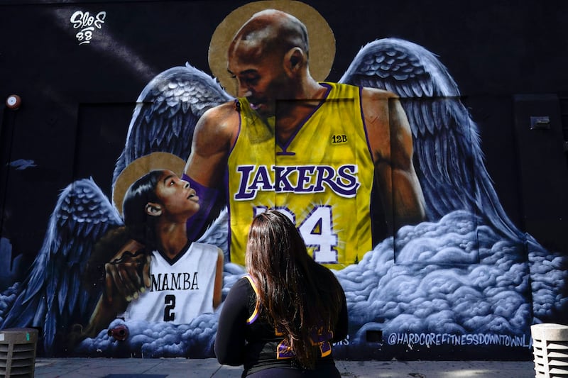 A woman looks up at a mural of Bryant and Gianna in Los Angeles. AP