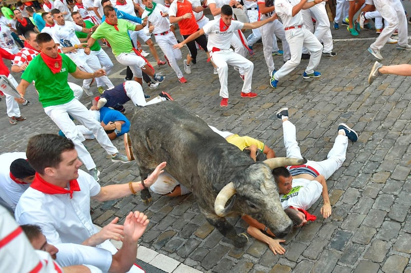 Participants fall next to a Cebada Gago fighting bull.  Ander Gillenea / AFP
