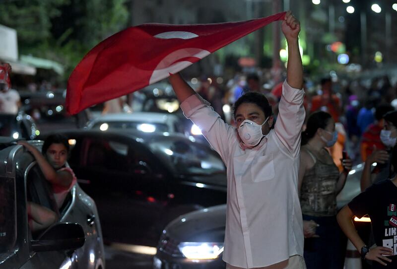 A woman raises the Tunisian flag.