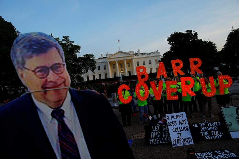 A cardboard cutout of US Attorney General William Barr is seen as protesters hold signs which read 'Barr Coverup' at the White House in Washington. Reuters