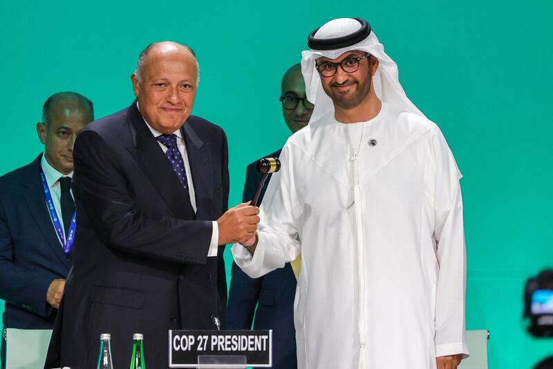 Cop27 President Sameh Shoukry, left, hands over the gavel to Cop28 President Dr Sultan Al Jaber at the UN climate conference's opening ceremony. AFP