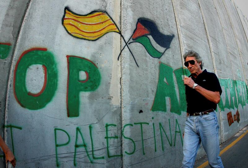 FILE PHOTO: British rock star Roger Waters of Pink Floyd walks along the controversial Israeli barrier in the West Bank city of Bethlehem, June 21, 2006.  REUTERS/Ahmad Mezhir/File Photo