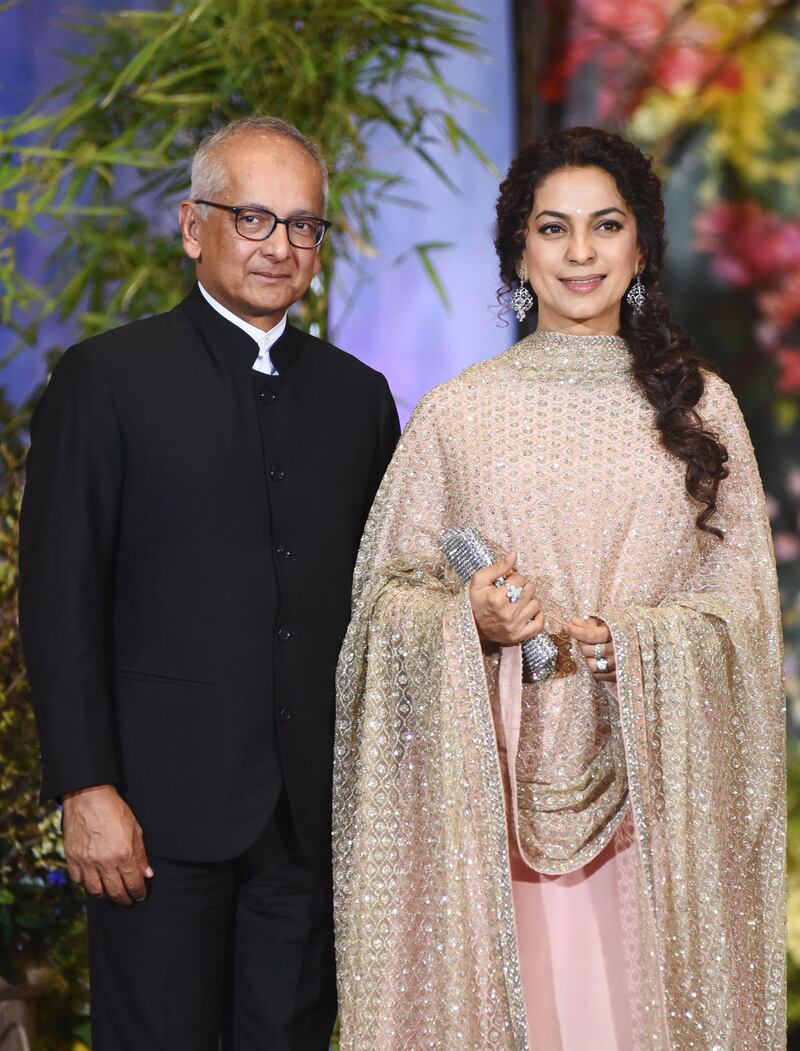 Indian Bollywood actress Juhi Chawla with her husband Jay Mehta pose for a picture during the wedding reception of actress Sonam Kapoor and businessman Anand Ahuja in Mumbai late on May 8, 2018. / AFP PHOTO / Sujit Jaiswal