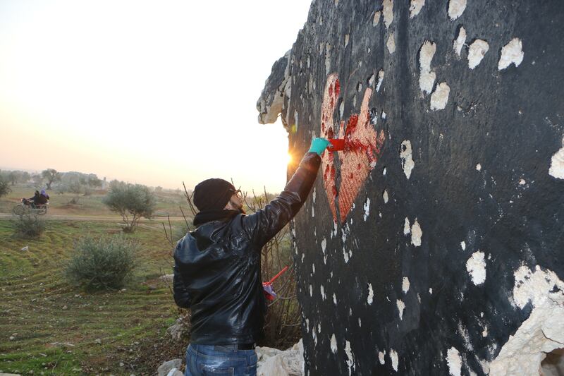 The winter of 2019 in Dair Al-Zugub, in North Idlib, Al Shami draws on a ruined roof as the sun is about to set. Abd Almajed Alkahr/ The National