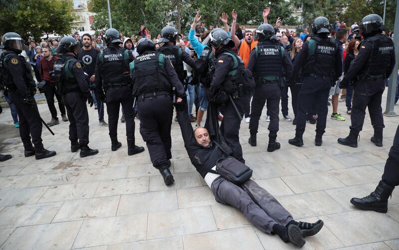 A man is dragged away, after scuffles broke out with Spanish Civil Guard officers, outside a polling station for the banned independence referendum in Sant Julia de Ramis, Spain. Albert Gea / Reuters