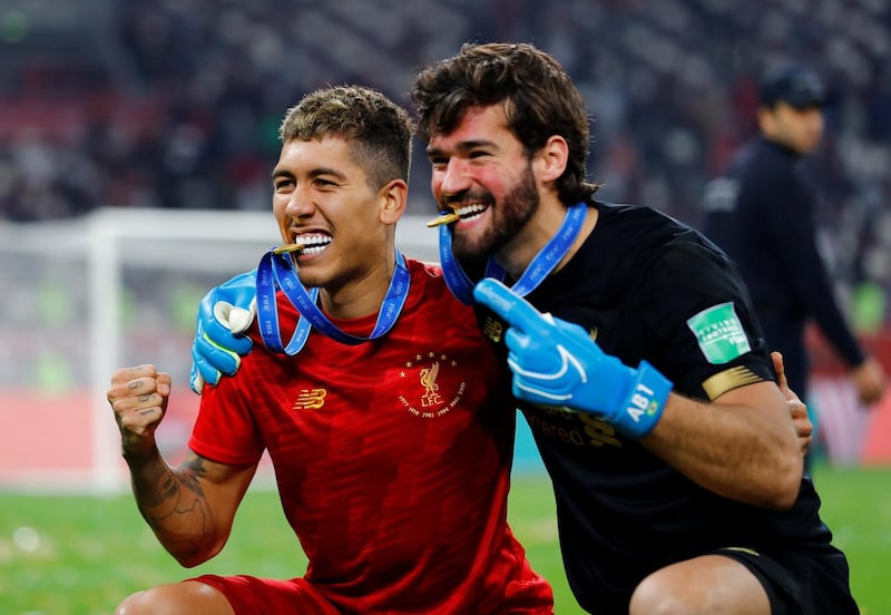 Liverpool's Roberto Firmino and Alisson celebrate winning the Club World Cup. Reuters