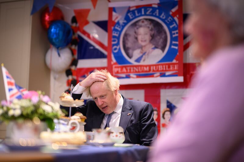 Mr Johnson chats with residents in a Diamond Jubilee-themed room as he makes a constituency visit to Sweetcroft care home in Uxbridge, in May 2022. Getty Images