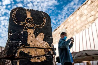A visitor takes pictures next to an unearthed wooden coffin during the official announcement of the discovery by an Egyptian archaeological mission of a new trove of treasures at Egypt's Saqqara necropolis south of Cairo, on January 17. AFP