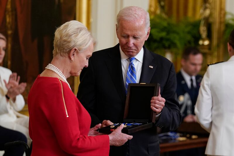Ms McCain accepts the medal on behalf of her late husband John. AP