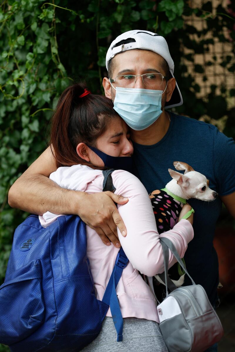 A couple embraces outside their home as they wait for the all-clear to return to their apartment in Mexico City. AP