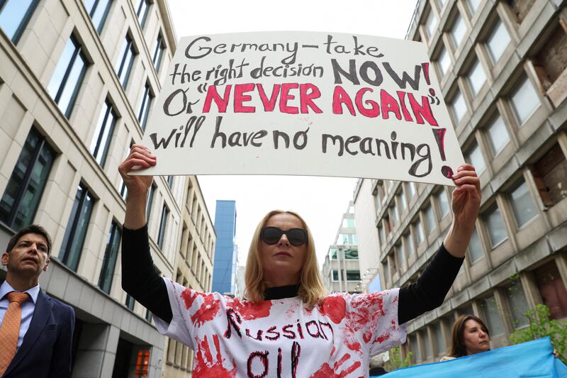 A demonstrator holds a banner as Climate activists protest in front of the German Embassy on Earth Day to call for an immediate embargo on Russian oil and gas, in Brussels, Belgium, April 22, 2022.  REUTERS / Johanna Geron